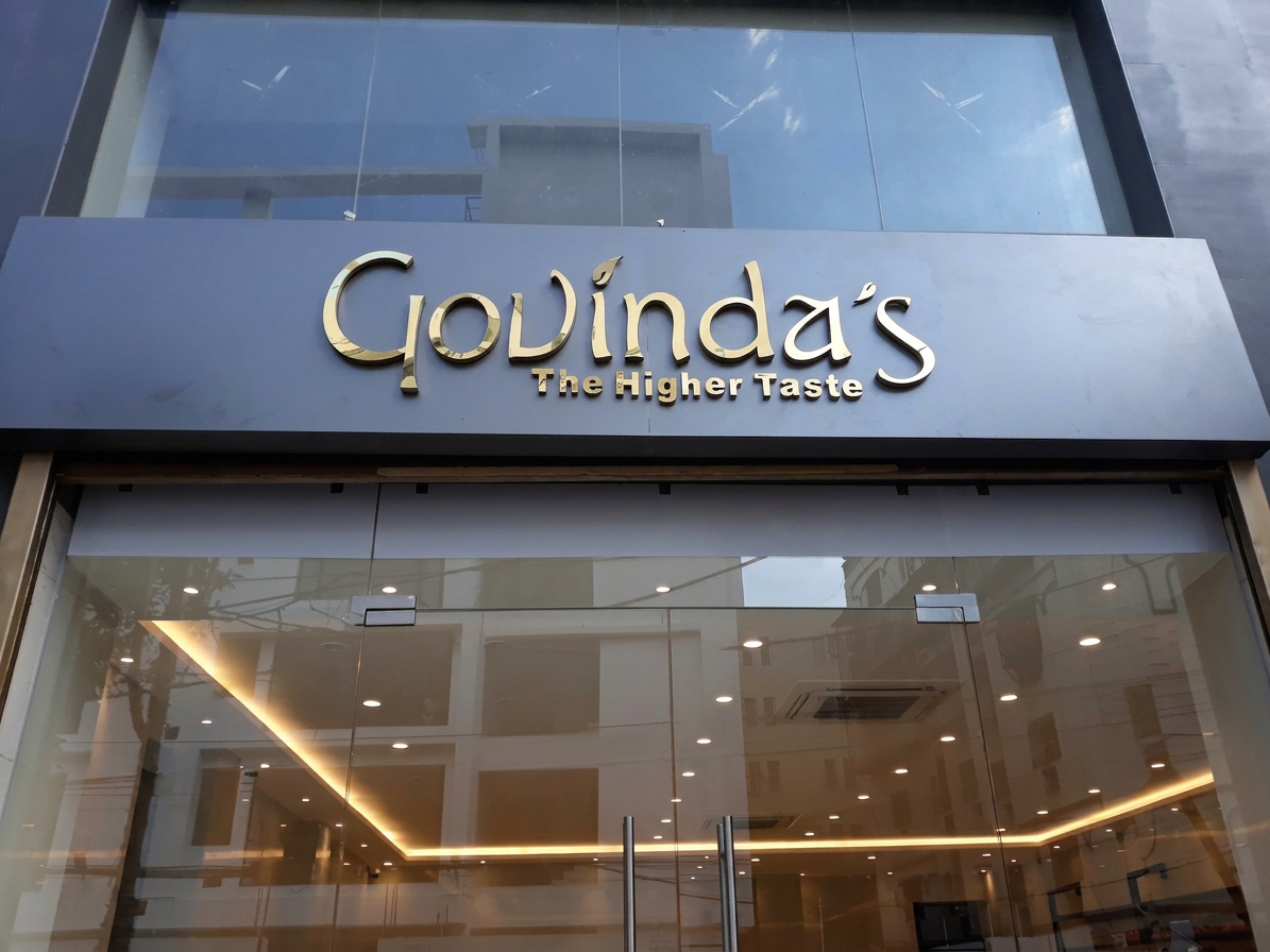 Premium gold acrylic signage on charcoal facade
